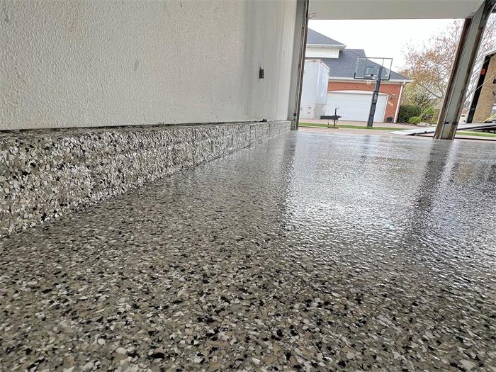Freshly coated decorative flake garage floor at the driveway transition